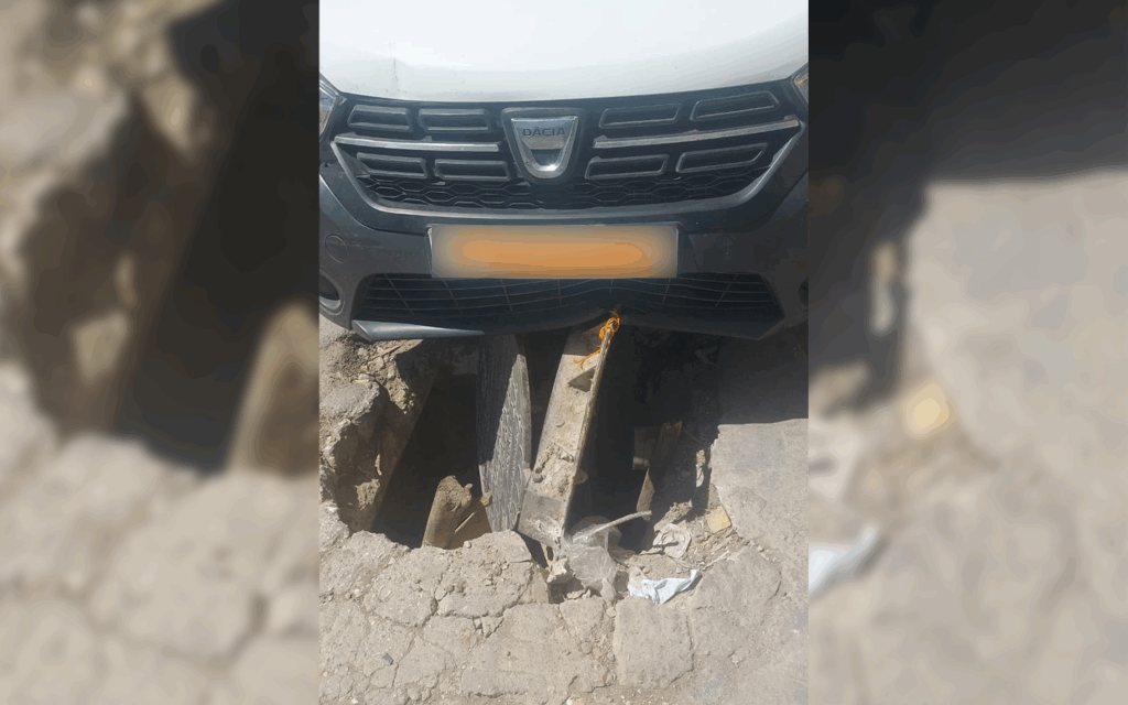 سيدي إدريس بطنجة.. سيارة تعلق داخل حفرة بسبب غطاء صرف صحي متهالك